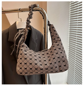 Detail of gingham crescent bag featuring black bows and a scrunchie pleated handle
