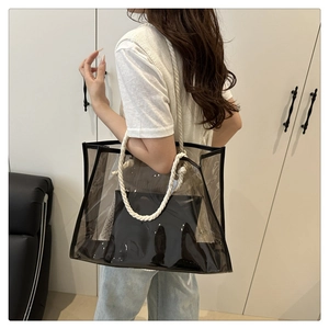 Detail view of transparent PVC tote bag with thick cotton rope handles and black inner pouch