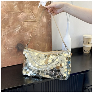 Close-up of shimmering silver and gold sequins on a stylish crescent shoulder bag