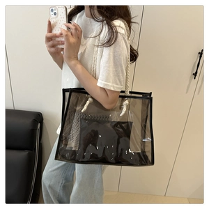 Close-up of gray transparent PVC tote bag featuring rope handles and inner pouch
