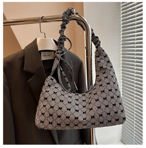 Detail of checkered shoulder bag with black bow embroidery and scrunched strap design