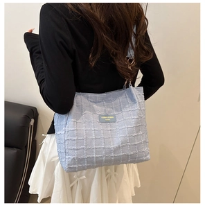 Detail of light blue quilted tote bag fabric with Canres & Heka brand label