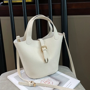 Chic beige lychee grain leather bucket bag with gold hardware and adjustable strap