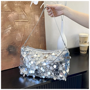 Macro detail of sparkling silver sequin handbag with elegant metal chain and zipper