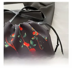 Detail of drawstring closure and persimmon pattern on Chinese style black crossbody bag