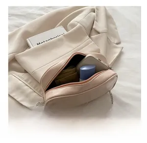 Detail view of the open pale pink crossbody bag showing interior capacity and silver chain