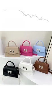 Borse a trapezio con fiocco in sei colori esposte su un moderno supporto bianco a gradini