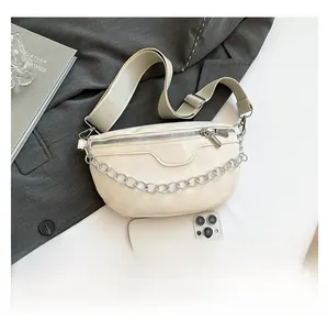 Detailed size comparison of beige leather crescent crossbody bag with a smartphone