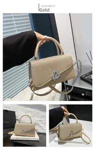 Detail view of champagne gold evening handbag with glitter heart clasp and top handle