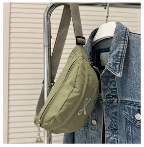 Détail du sac de sport en nylon vert armée clair avec broderie et breloque de fermeture