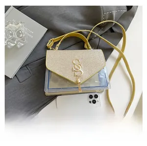 Macro view of clear PVC bag with gold sequins, metal SS logo and stylish tassel detail