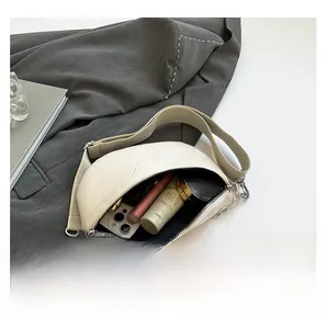 Top-down view of cream crescent bag interior showing spacious storage for cosmetics and phone