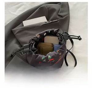 Internal view of a black silk bucket bag showing capacity for phone and wallet