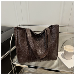 Close-up of premium brown woven leather texture on a large capacity tote bag