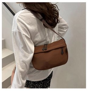 Brown nylon crescent bag detail showing adjustable strap and double zipper pockets