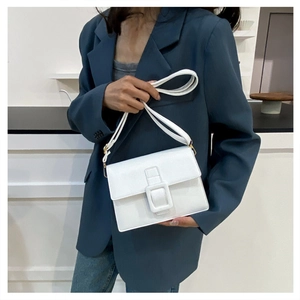 Detail of white leather shoulder bag with a large square buckle and gold hardware