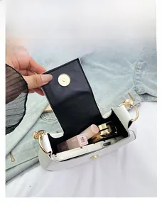 Dettaglio della capacità interna di una borsa a tracolla bianca con chiusura magnetica oro