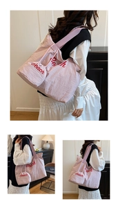 Detailed view of pink nylon tote bag with red Beach embroidery and mini drawstring pouch