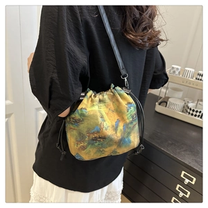 Detail of drawstring bucket bag with traditional landscape art and slim leather strap