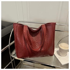 Detail of red woven texture on a large tote bag with wide shoulder strap design