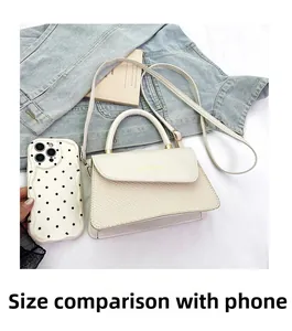 Detail showing cream crossbody bag with woven texture next to a phone for size comparison