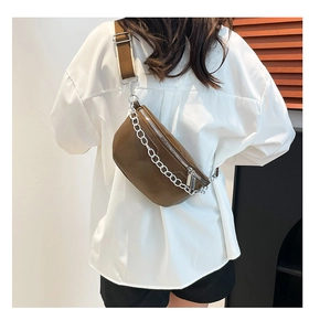 Detail of dark brown leather chest bag with chunky silver chain and wide strap