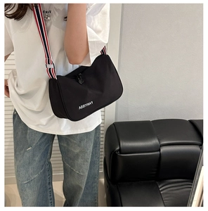 Détail du sac bandoulière noir en nylon avec sa sangle rayée tricolore rouge blanc bleu