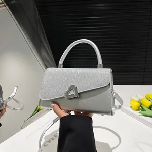 Sparkly silver sequined handbag with heart-shaped lock and elegant metal handle