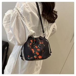 Detail of black drawstring bucket bag with persimmon pattern and Ruyi calligraphy