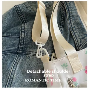 Detail of adjustable and detachable strap on white floral canvas crossbody bag