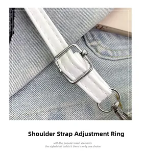Detail of adjustable silver buckle and white leather strap on a denim backdrop