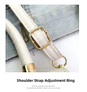 Detailed close-up of white leather shoulder strap with golden adjustable buckle and stitching