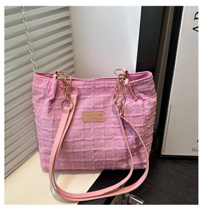 Detail of pink plaid textured fabric tote bag with golden chain and leather strap