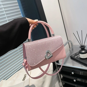 Pink sequined handbag with heart-shaped lock and silver chain for spring 2025 fashion