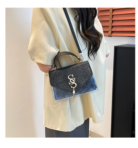 Detail of glittery flap and blue translucent body with golden tassel on small crossbody bag