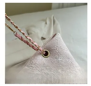 Détail d'un sac cabas rose clair avec broderie florale et œillet métallique doré