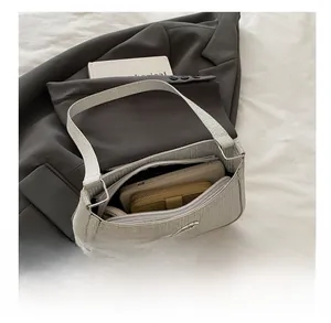 Silver knit shoulder bag with bow detail showing spacious interior for phone and wallet