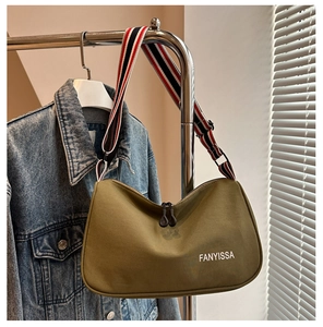 Détail du sac bandoulière en toile vert olive avec large sangle rayée et double zip