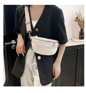 Detail view of white crescent bag with silver chain and adjustable canvas strap on model