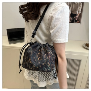 Close-up of vintage floral Xiangyunsha bucket bag with adjustable black shoulder strap