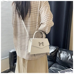 Vista posteriore dettagliata della borsa bianca con fiocco d'argento su una modella