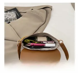 Top view of the spacious inner compartment of this brown chain shoulder bag
