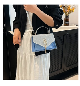 Detail showing blue transparent PVC crossbody bag with silver glitter and gold SS logo