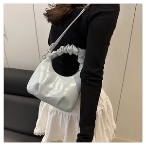 Detail of light blue patent leather cloud bag with ruched handle and silver hardware