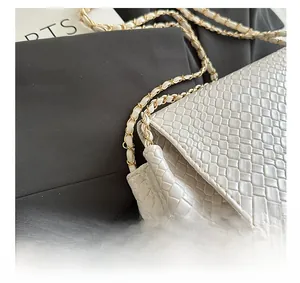 Détails de la texture tissée en cuir blanc avec une élégante chaîne dorée