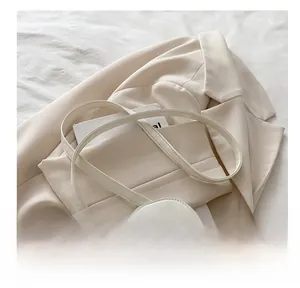 Detailed view of quilted square crossbody bag with adjustable strap and golden hardware