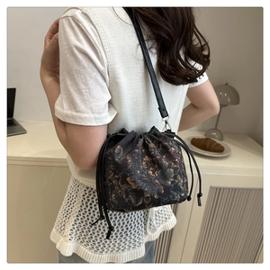 Sac seau à cordon fleuri avec bandoulière présenté dans un cadre de style de vie