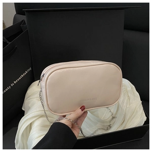 Elegant beige chain bag with silver strap displayed in a luxury gift box with satin
