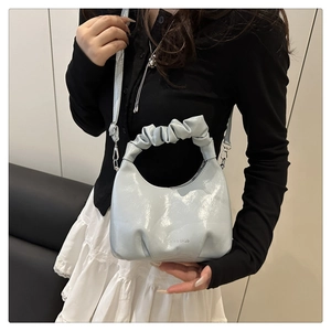 Detail of light blue pleated handle shoulder bag featuring the FASHION & BAGS logo