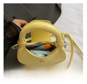 Detail view of the yellow dumpling bag interior showing capacity for cosmetics and essentials